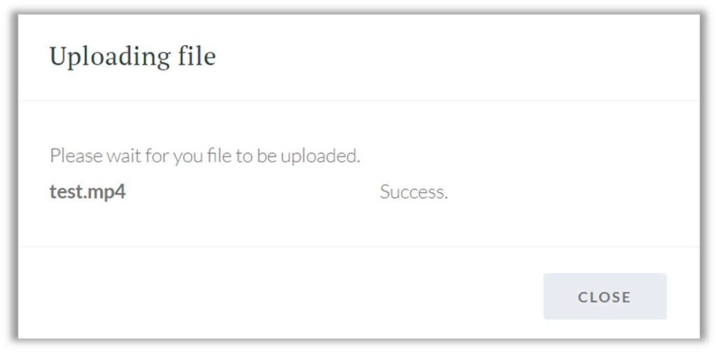 File upload confirmation dialog in the Transcriber AI application. The dialog displays a message: 'Please wait for your file to be uploaded,' followed by the file name 'test.mp4' and its status as 'Success.' At the bottom right, there is a 'Close' button to dismiss the dialog.